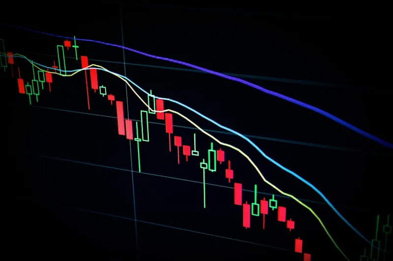 Physical Bitcoin coin resting on a candlestick price chart used to compare asset classes