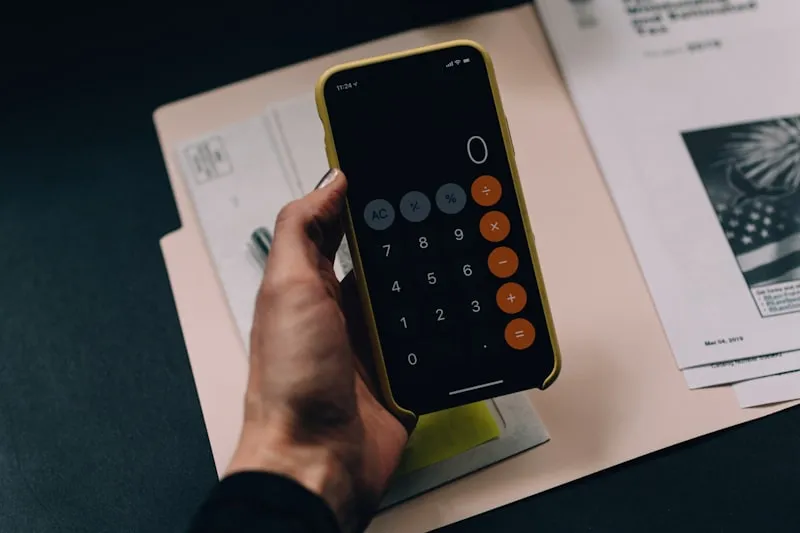 Calculator and tax-return paperwork on a desk, illustrating UK HMRC reporting for Bitcoin investors